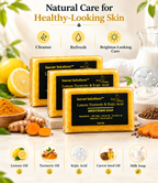 Three bars of Secret Solutions Lemon Turmeric & Kojic Acid Brightening Soap are displayed on a marble surface with lemons, turmeric root, and carrots. The background is a soft beige with decorative text and ingredient icons illustrating the product's benefits.