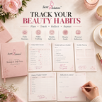 A styled flat-lay of the Secret Solutions 'The Smart Beauty & Self Care Planner' on a light pink background, showing the pink hardcover planner, several open tracking sheets, decorative flowers, a candle, and a hand writing in the journal.